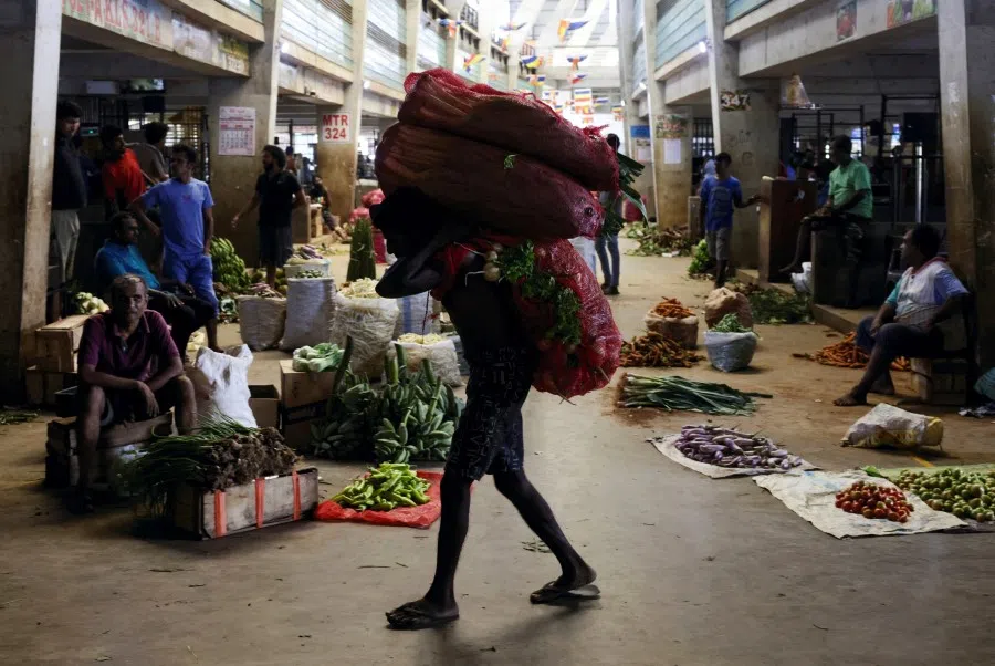 A worker carries a sack of vegetables at a market in Colombo, Sri Lanka, 1 June 2023. (Dinuka Liyanawatte/Reuters)