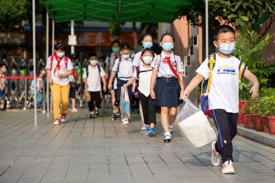 This photo taken on 1 September 2020 shows elementary school students arriving at school on the first day of the new semester in Wuhan, Hubei, China. (STR/AFP)