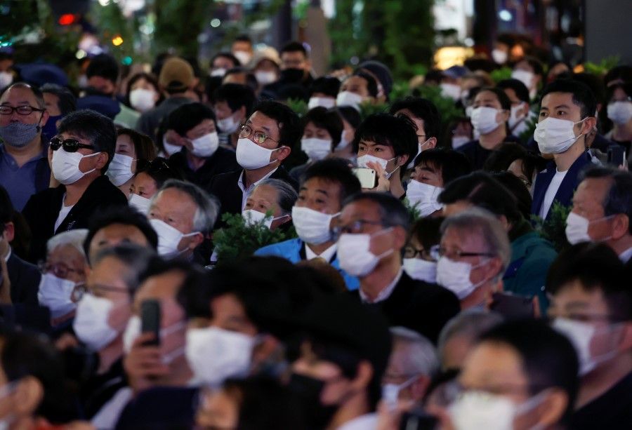 Voters wearing protective face masks listen to a speech by Japan's Prime Minister Fumio Kishida, who is also the President of the ruling Liberal Democratic Party, on the last day of campaigning for the 31 October lower house election, amid the coronavirus disease (Covid-19) pandemic, in Tokyo, Japan, 30 October 2021. (Issei Kato/Reuters)