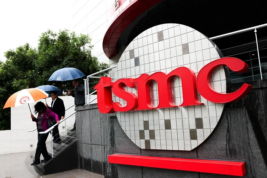 People walk beside Taiwan Semiconductor Manufacturing Company (TSMC) signage outside the company’s Museum of Innovation at its headquarters in Hsinchu on 21 November 2024.