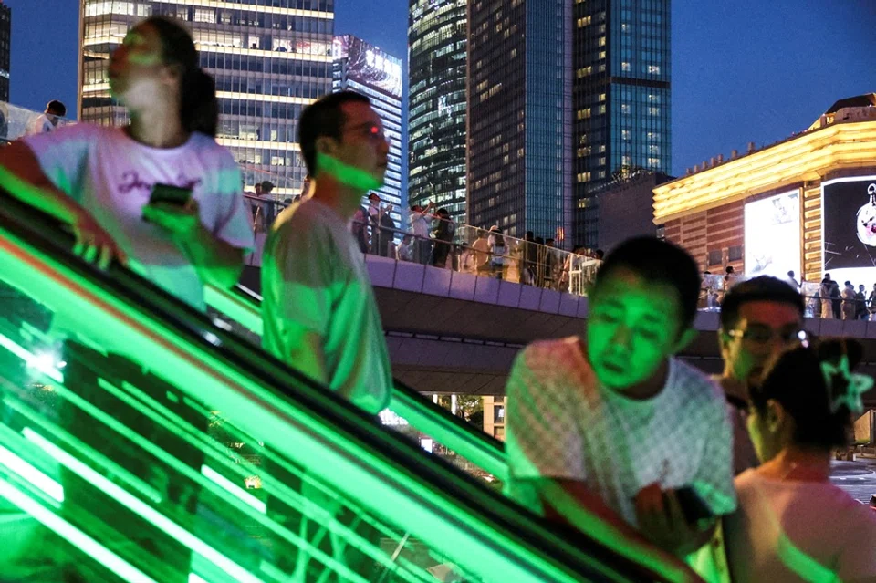 People ride an escalator at Lujiazui financial district in Shanghai, China, on 14 July 2025. (Go Nakamura/Reuters)