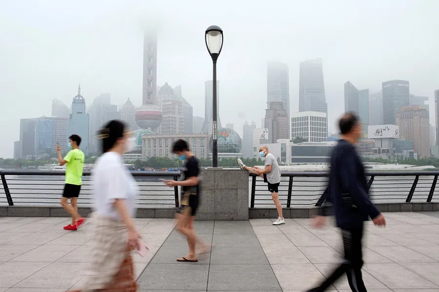People walk in the Lujiazui financial district in Shanghai, China, 1 June 2022. (Aly Song/Reuters)