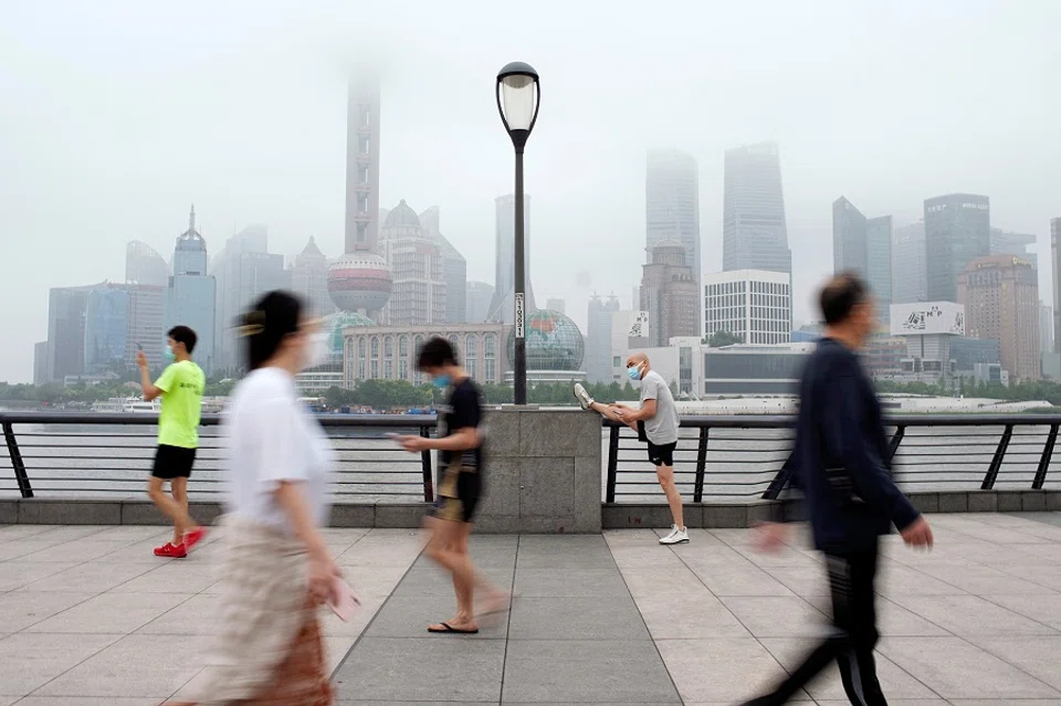 People walk in the Lujiazui financial district in Shanghai, China, 1 June 2022. (Aly Song/Reuters)