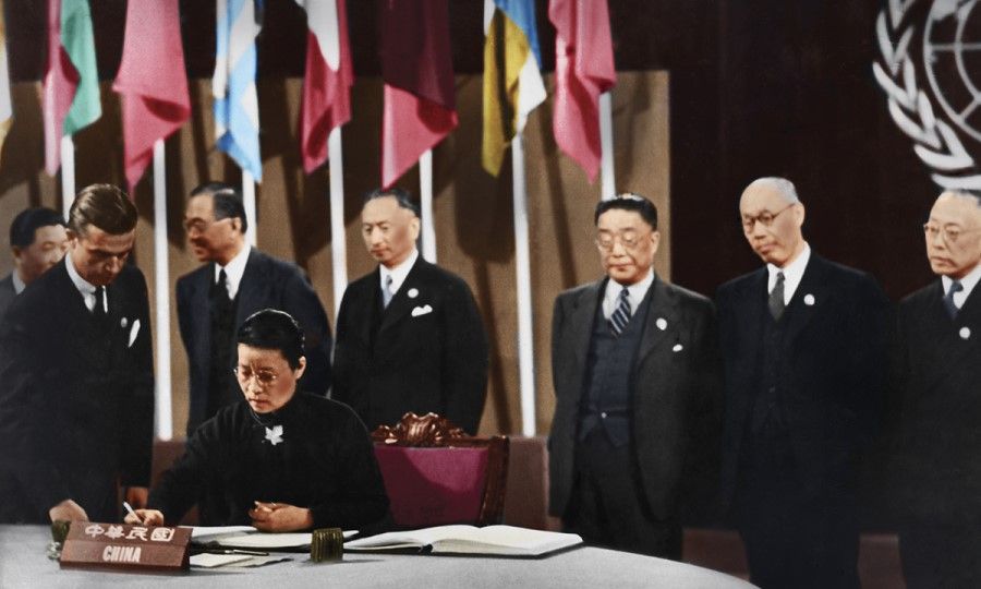 26 June 1945, San Francisco - Wu Yi-fang, principal of Ginling Women's College and a member of the Chinese delegation, is signing the UN Charter, becoming the first female delegate to sign the UN document. Standing next to her is Alger Hiss, executive secretary of the conference. Standing at the back row (from left) is Wei Tao-min, ambassador of the Republic of China to the US ; Wang Chun-hui, president of the People's Political Council; V.K. Wellington Koo, ambassador of the Republic of China to the UK; Hu Lin, editor-in-chief of the Ta Kung Pao; Dong Biwu, representative of the Chinese Communist Party; and Chang Chun-mai (Zhang Junmai), representative of the China Democratic Socialist Party.