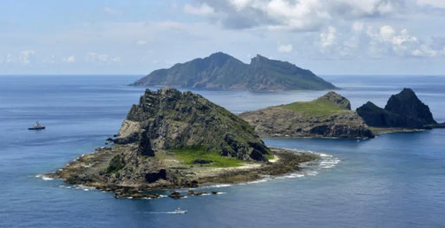 In this 2 September 2012 file photo, a survey ship (left), chartered by Tokyo city officials, sails around the tiny islands in the East China Sea, called Senkaku in Japanese and Diaoyu in Chinese. (Kyodo News)