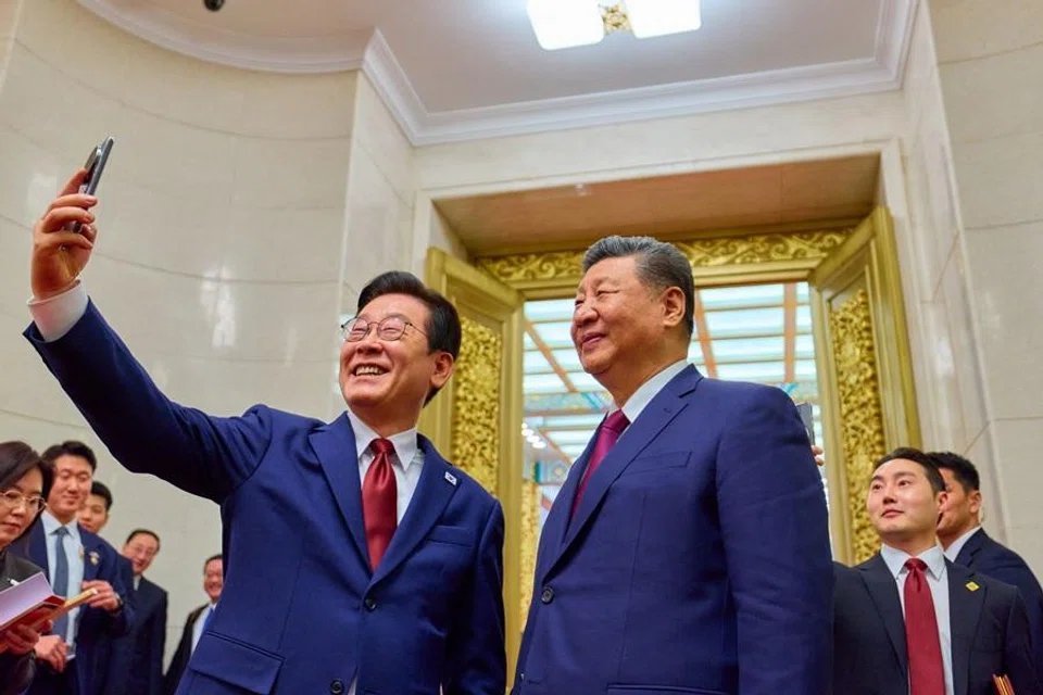 South Korea's President Lee Jae-myung (left) takes a selfie with China's President Xi Jinping after a dinner at the Great Hall of the People in Beijing on 5 January 2026. (Yonhap/AFP)