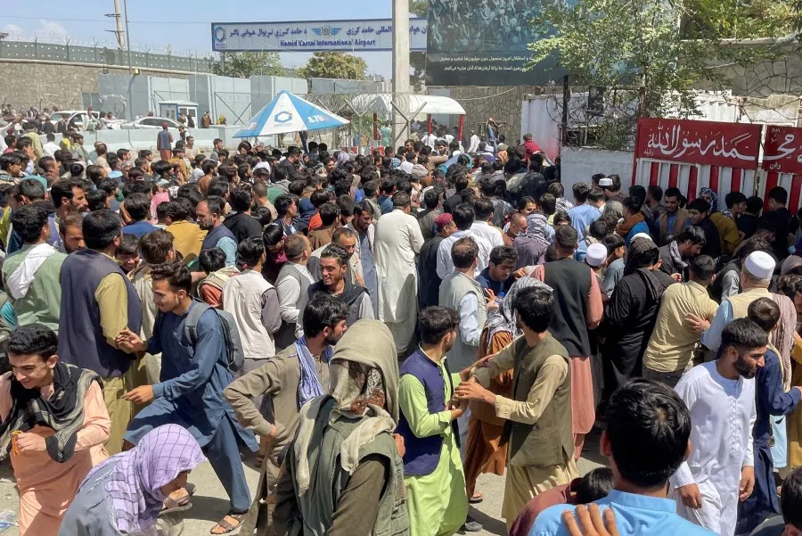 People try to get into Hamid Karzai International Airport in Kabul, Afghanistan, 16 August 2021. (Stringer/Reuters)