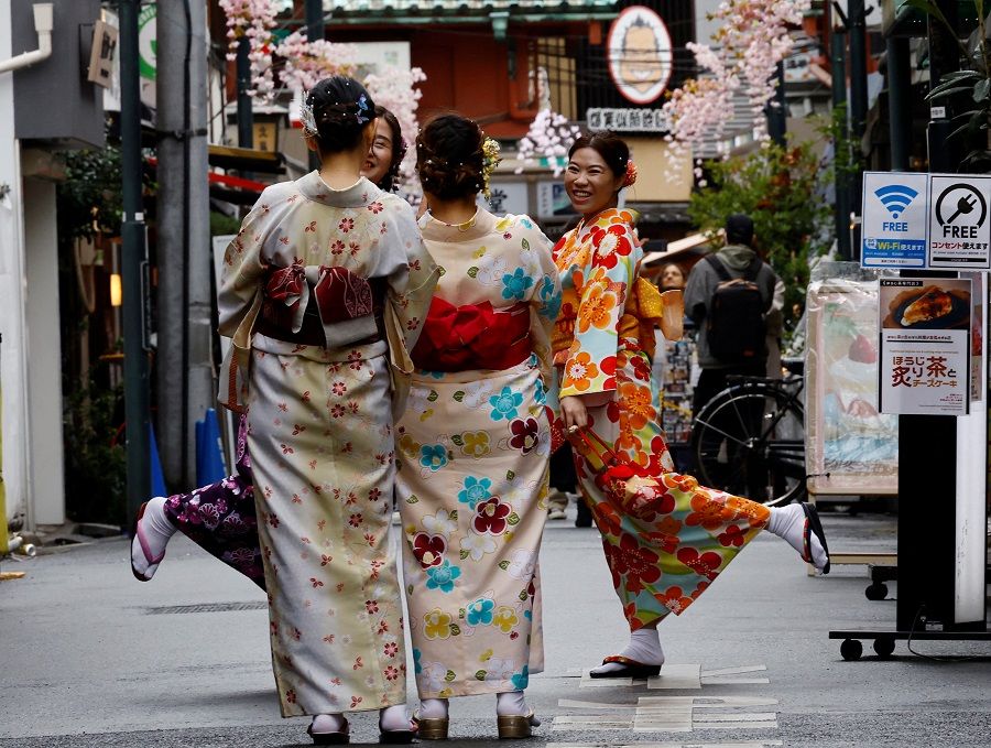People wearing kimonos take their photos at Asakusa district in Tokyo, Japan, 13 March 2023. (Kim Kyung-Hoon/Reuters)