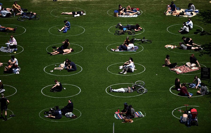 People are seen practising social distancing in white circles in Domino Park, during the Covid-19 pandemic on 17 May 2020, in the Brooklyn borough of New York City. (Johannes Eisele/AFP)