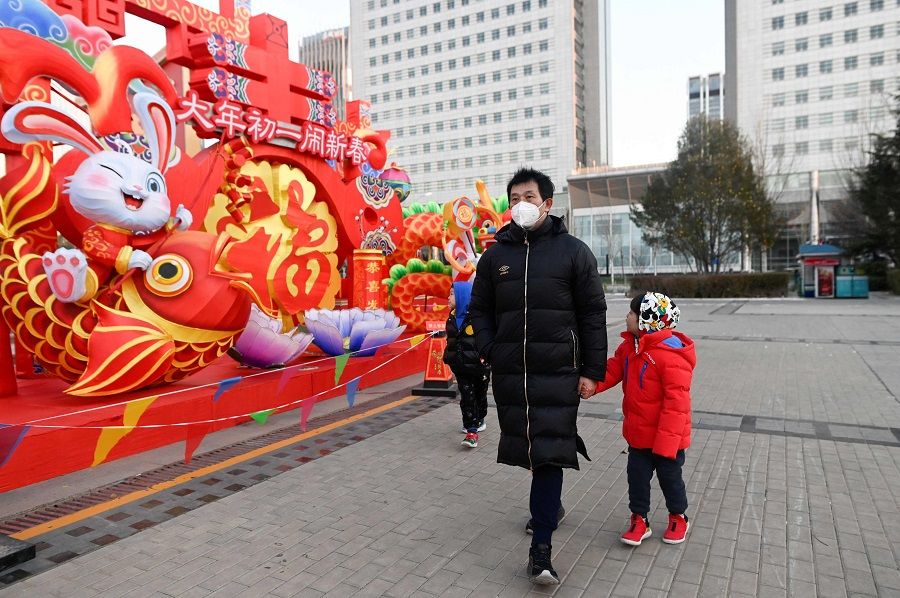 People walk past an installation for Chinese New Year celebrations in Beijing, China, on 24 January 2023. (Wang Zhao/AFP)