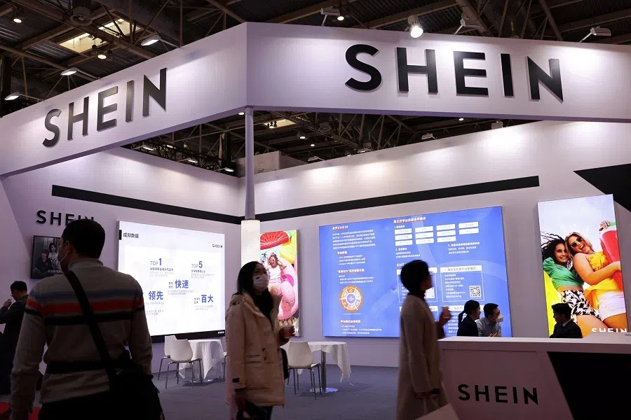 People walk past the booth of fashion retailer Shein during the China International Supply Chain Expo in Beijing, China, on 28 November 2023. (Florence Lo/Reuters)