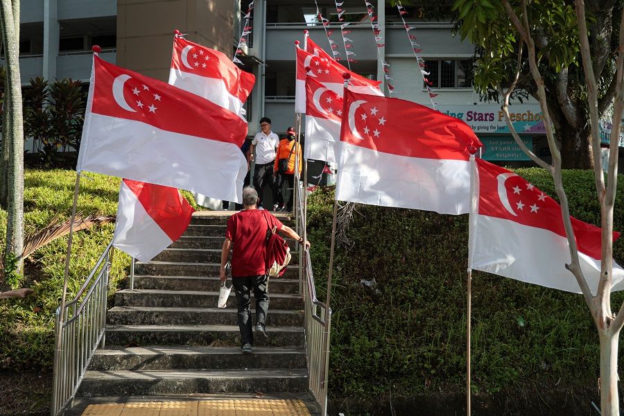 People walk past a neighbourhood decorated with Singapore flags in Singapore. (SPH Media)