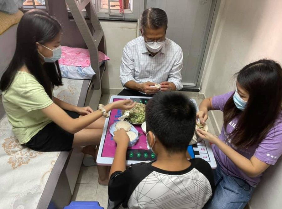 Hong Kong Financial Secretary Paul Chan wrapped and ate dumplings with Mdm Wong and her children. (Facebook/Ma Yat-chiu)