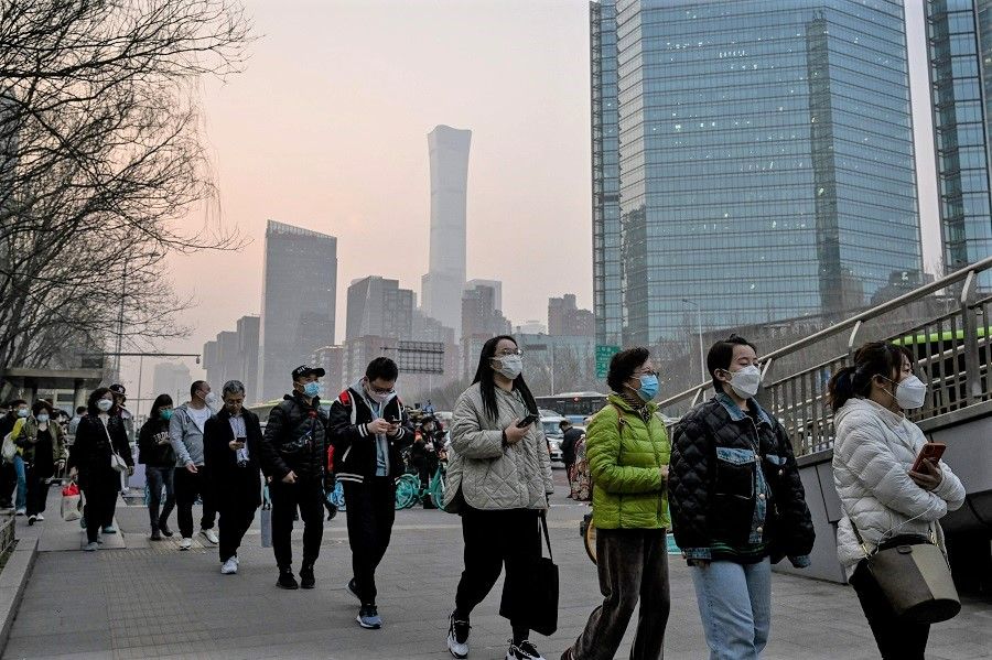 People wait for a bus in the central business district during rush hour in Beijing, China, on 7 March 2023. (Jade Gao/AFP)