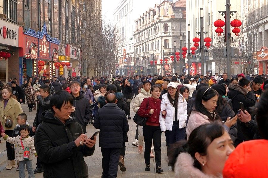 Visitors throng a pedestrian shopping street in Shanghai, China, on 10 February 2024. (Nicoco Chan/Reuters)