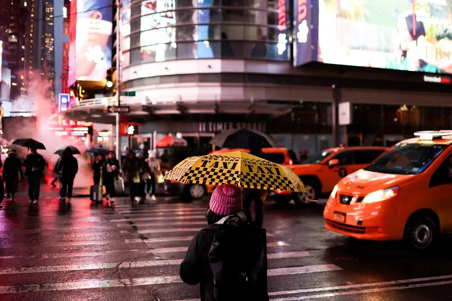 People hold umbrellas as they walk under the rain in a street of the Manhattan borough of New York City on 22 November 2024. (Charly Triballeau/AFP)