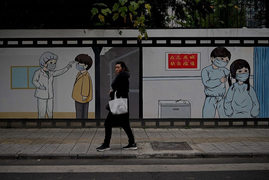 A woman walks along a street in Chengdu, Sichuan province, 27 November 2020. (Noel Celis/AFP)