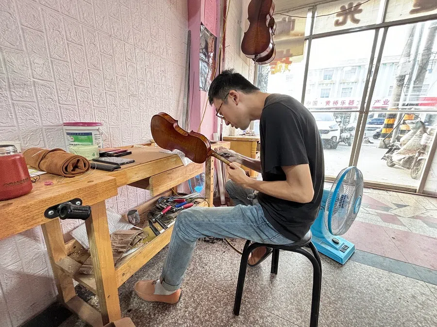 Lu Xin working on a violin. 