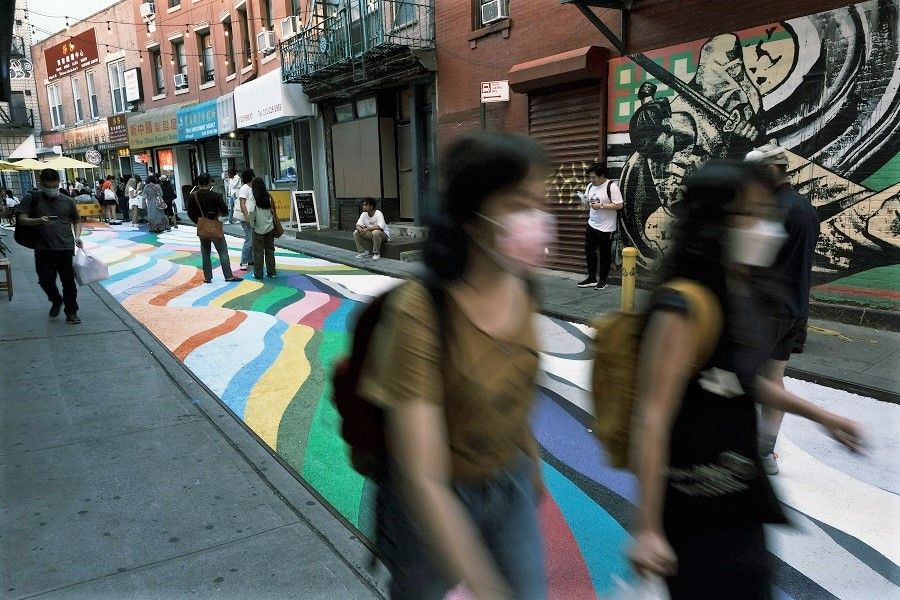 People walk on the historic Doyers Street in Chinatown that has been painted over by Chilean-born street artist Dasic Fernandez, 24 June 2021 in New York City, US. (Spencer Platt/Getty Images/AFP)