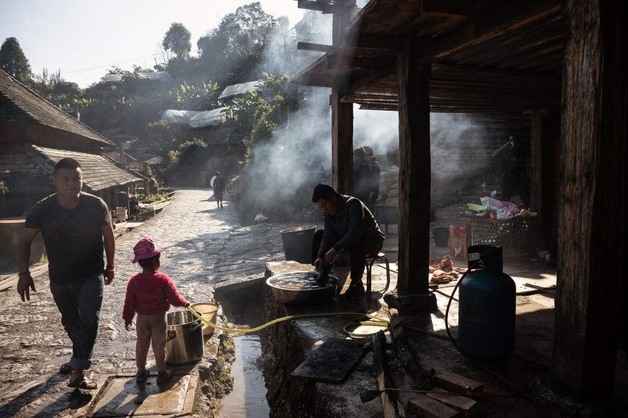 This photo taken on 11 January 2023 shows an ethnic Blang people cooking pork in Wengji village in Jingmai mountain, in Pu'er City in southwest China's Yunnan Province. (Noel Celis/AFP)