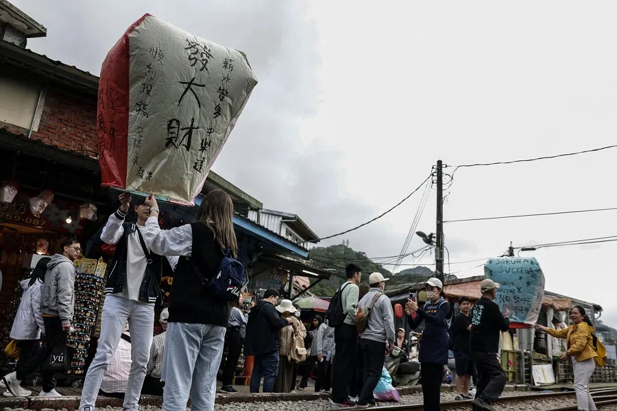 Tourists release sky lanterns in Pingxi Old Street during the Lantern Festival in New Taipei City on 17 February 2024. (I-Hwa Cheng/AFP)