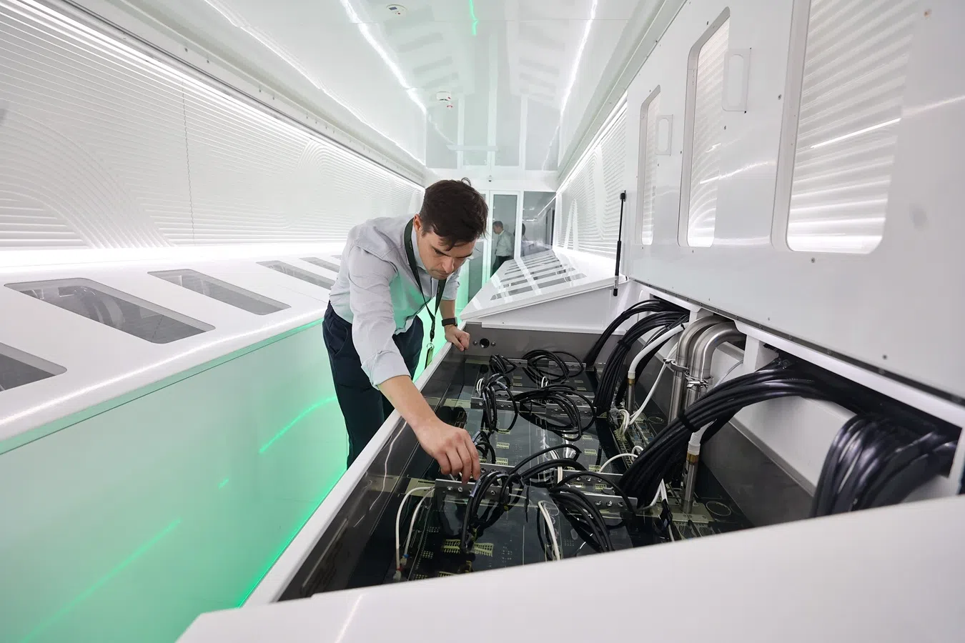 Tim Rosenfield, co-CEO and co-founder of Singapore-based data centre operator Sustainable Metal Cloud, demonstrates how the “Sustainable AI Factory” achieves cooling through the use of cooling liquids. (SPH Media)