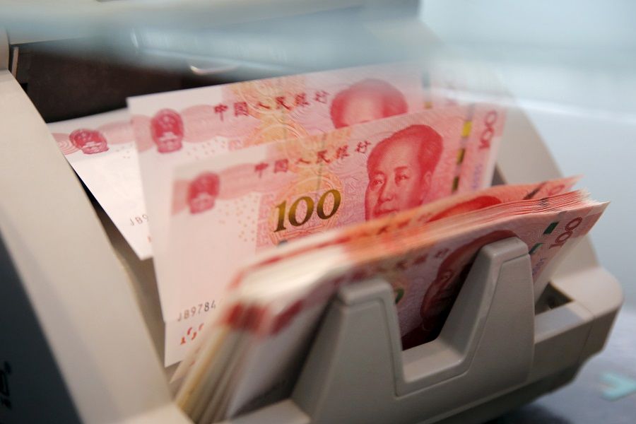 Chinese 100 RMB banknotes are seen in a counting machine while a clerk counts them at a branch of a commercial bank in Beijing, China, in this 30 March 2016 file picture. (Kim Kyung-Hoon/File Photo/Reuters)