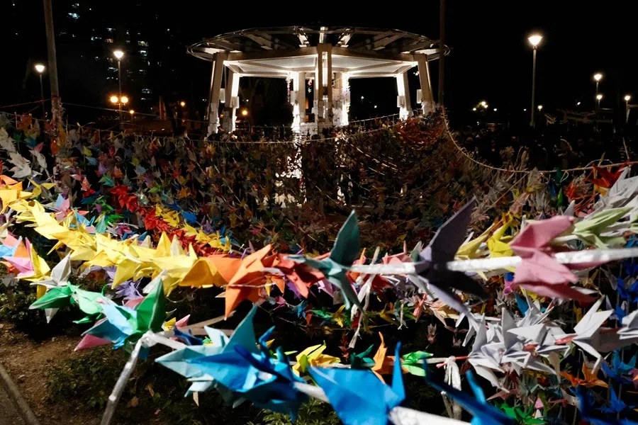 Paper cranes are seen hung on strings during a vigil held outside the Wang Fuk Court apartment blocks in the aftermath of the deadly 26 November fire in Hong Kong’s Tai Po district on 3 December 2025. (Tommy Wang/AFP)