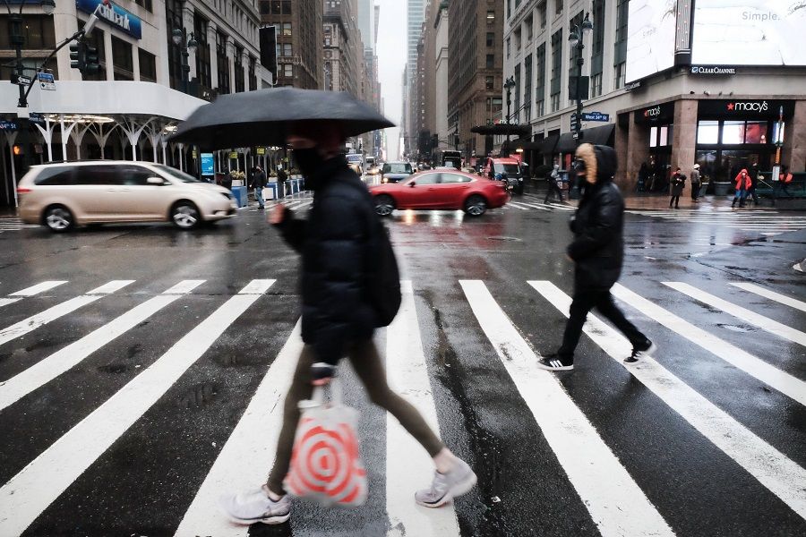 People walk through the rain in Manhattan on 4 February 2022 in New York City, US. (Spencer Platt/Getty Images/AFP)
