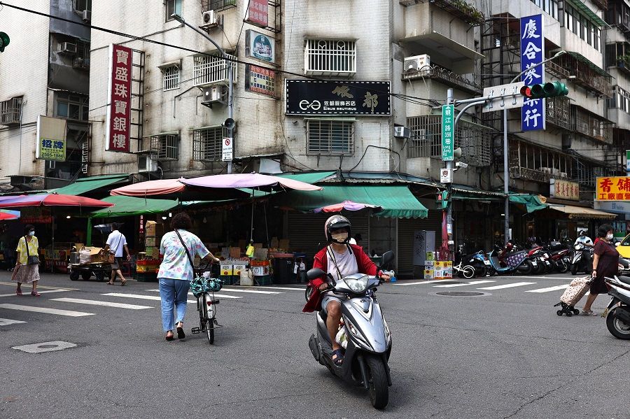 People and traffic pass near a marketplace in Taipei, Taiwan, 4 August 2022. (Ann Wang/Reuters)