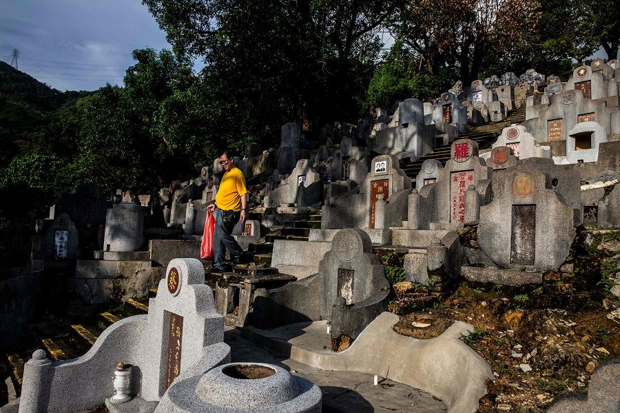 A man walks through a cemetery in Diamond Hill in Hong Kong on 14 October 2021, during the Chung Yeung Festival, also known as the Double Ninth Festival, where people honour their ancestors. (Isaac Lawrence/AFP)