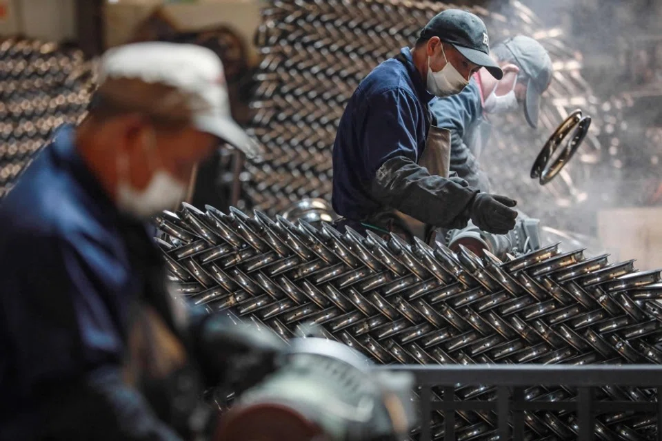 Workers polish steel rims at a factory producing bicycle parts for export in Hangzhou, in eastern China's Zhejiang province on 18 February 2024. (AFP)