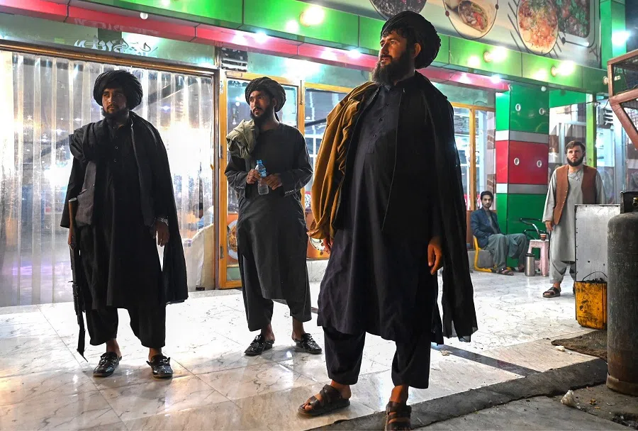 Taliban security personnel stand outside a restaurant in Kandahar on 25 August 2024.