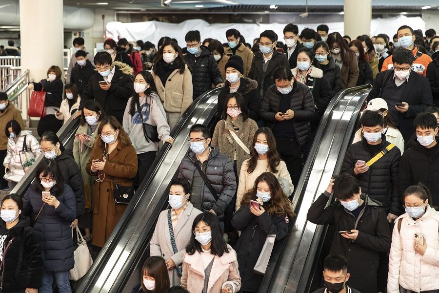 Commuters ride on an escalator at a subway station in Shanghai, China, on 17 December 2021. (Qilai Shen/Bloomberg)