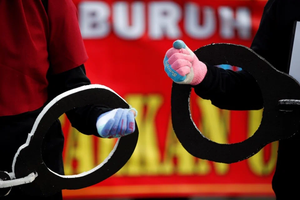 Members of Indonesian Trade Unions carry giant handcuffs during a protest against the government's labor reforms in a "job creation" bill in Jakarta, Indonesia, 10 November 2020. (Willy Kurniawan/REUTERS)