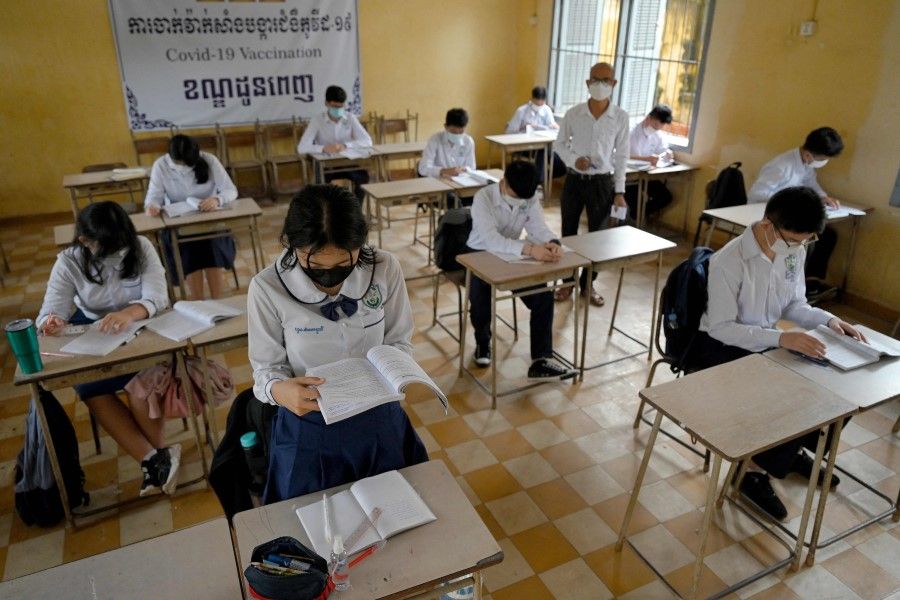 Students sit socially distanced in a classroom in Phnom Penh on 15 September 2021, as Cambodia reopened schools in low-risk Covid-19 coronavirus areas. (Tang Chhin Sothy/AFP)