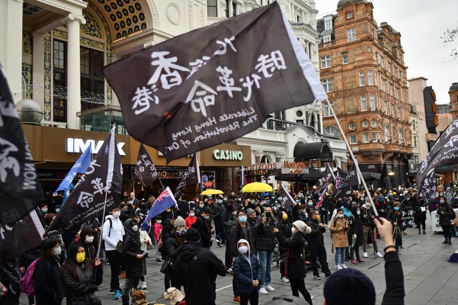 Protesters gather with flags and placards at an event organised by Justitia Hong Kong to mourn the loss of Hong Kong's political freedoms, in Leicester Square, central London on 12 December 2020. (Justin Tallis/AFP)