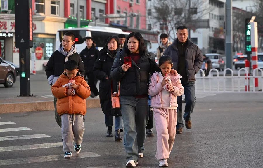 People cross a road in Luliang, northern China’s Shanxi province on 11 February 2025. (Adek Berry/AFP)