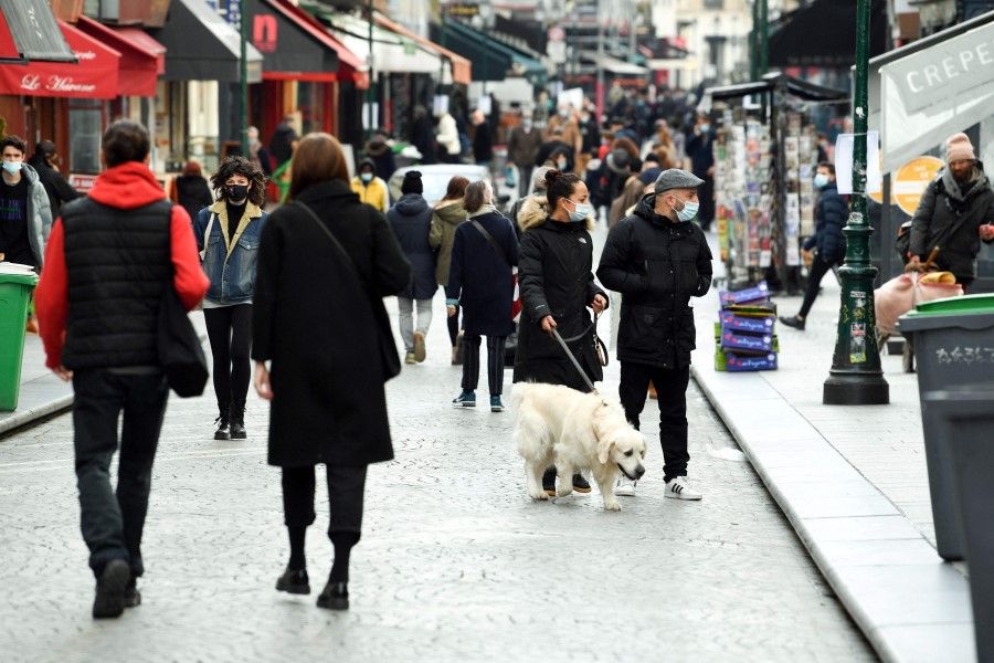 People walk on a pedestrian street in Paris with non-essential shops shut on the first day of a one-month lockdown aimed at curbing the spread of the Covid-19 pandemic in the Ile-de-France region on 20 March 2021. (Alain Jocard/AFP)