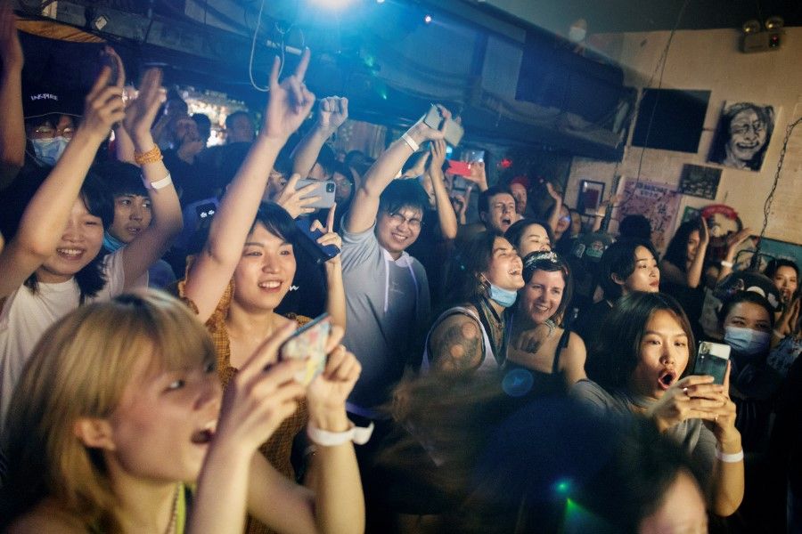 People dance during a concert by the art rock band Macondo at a livehouse following an outbreak of the coronavirus disease (COVID-19) in Beijing, 18 July 2020. (Thomas Peter/REUTERS)