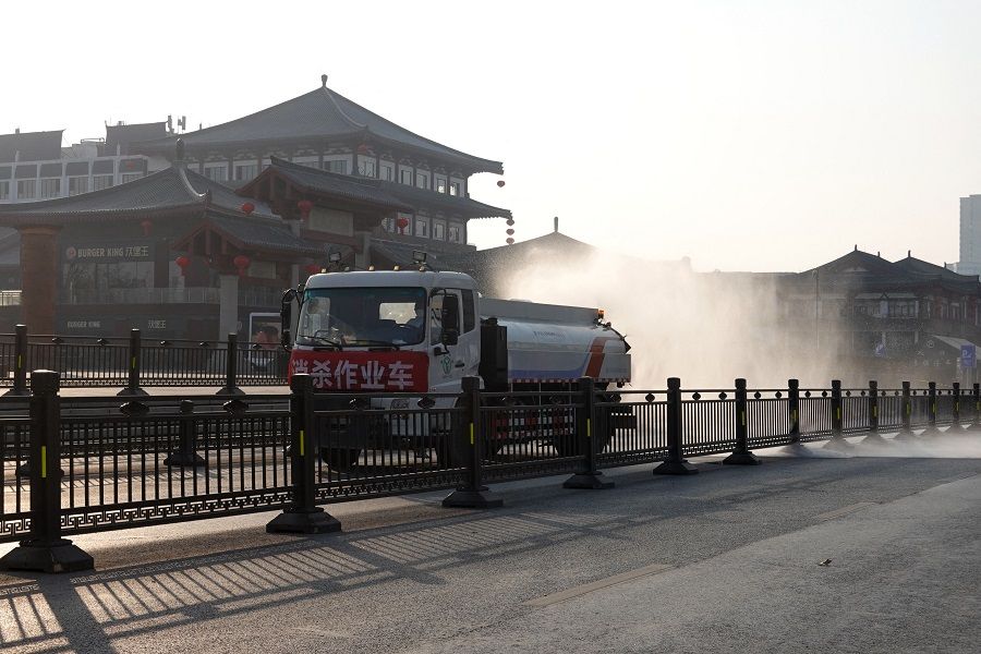 A truck sprays disinfectant on a street in Xi'an, Shaanxi province, China, on 31 December 2021, amid a Covid-19 coronavirus lockdown. (AFP)