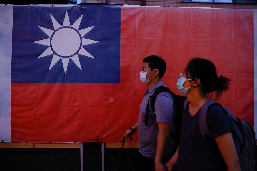 People walk past a Taiwan flag in Taipei, Taiwan, on 18 August 2023. (Ann Wang/Reuters)