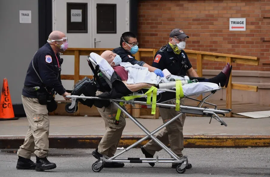 Healthcare workers transport a patient from an ambulance to Maimonides Medical Center, a hospital in the Brooklyn neighborhood of Borough Park, on 4 January 2021 in New York City. (Angela Weiss/AFP)