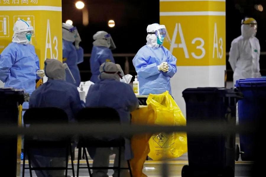 Workers in protective suits are seen at a makeshift nucleic acid testing site inside a parking lot of Shanghai Pudong International Airport, after new cases of coronavirus disease (Covid-19) in Shanghai, China, 22 November 2020. (CNS photo via Reuters)