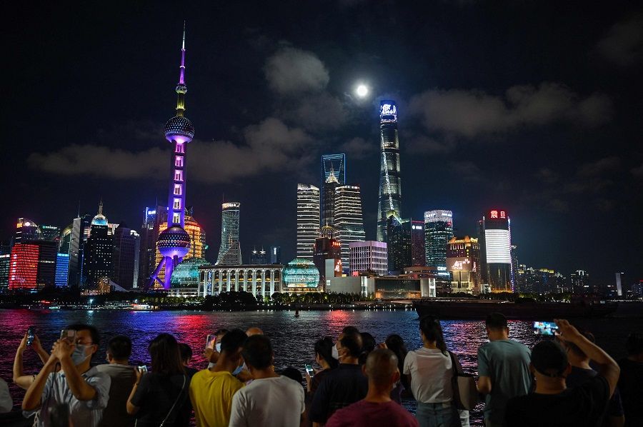 People at the Bund promenade along the Huangpu River in Shanghai, China, on 10 September 2022. (Hector Retamal/AFP)