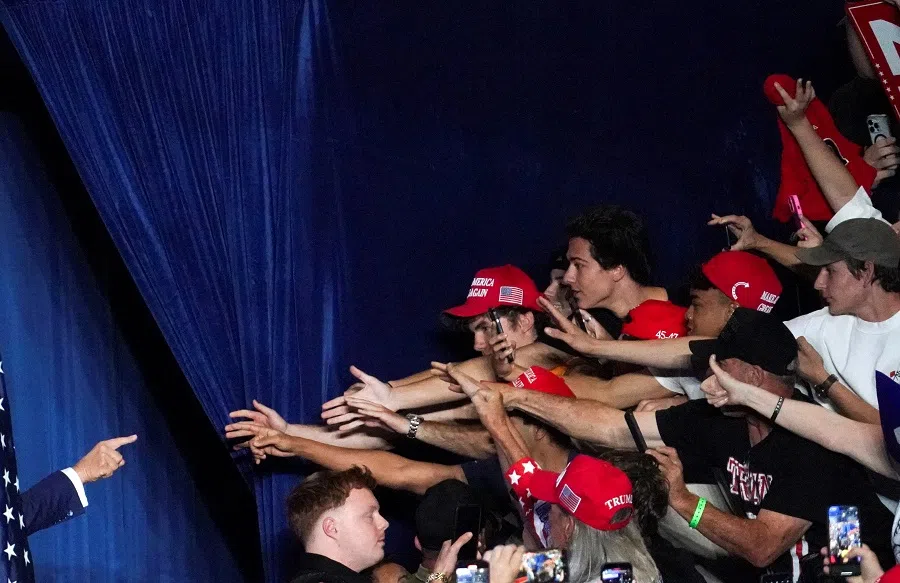Republican presidential nominee and former US President Donald Trump points towards supporters during a rally at Mullett Arena in Tempe, Arizona, US, on 24 October 2024. (Go Nakamura/Reuters)