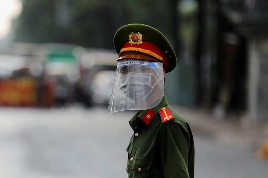 A policeman wears a face mask and shield while patrolling amid the Covid-19 outbreak in Ho Chi Minh city, 1 June 2021. (Stringer/Reuters)