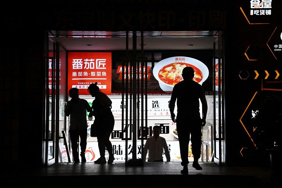 People leave a food court at a mall in Beijing, China, on 15 August 2023. (Greg Baker/AFP)