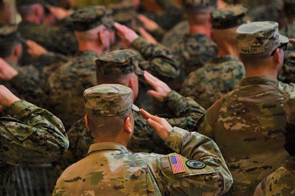 Philippines and US soldiers salute in front of their national flags while their national anthems are played during the opening ceremony of the 'Balikatan' joint military exercise at the military headquarters in Quezon City, suburban Manila on 11 April 2023. (Ted Aljibe/AFP)