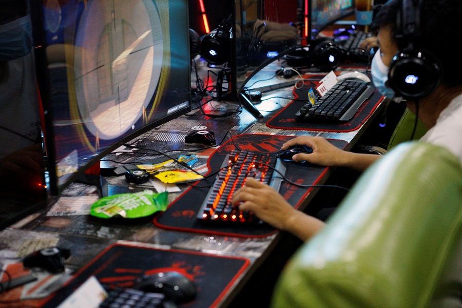 A man plays an online game on a computer at an internet cafe in Beijing, China, 31 August 2021. (Florence Lo/Reuters)